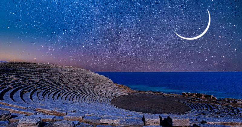Ancient Greek amphitheater by the sea with crescent Leo New Moon in a starry sky.