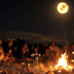 Full Moon in Leo, February 2025, a group of people sit around a roaring fire under the gaze of the Full Moon in Leo.